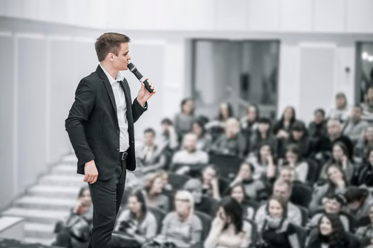 Hombre en terno hablando al publico